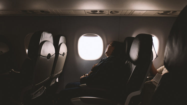 Woman sleeping on plane.
