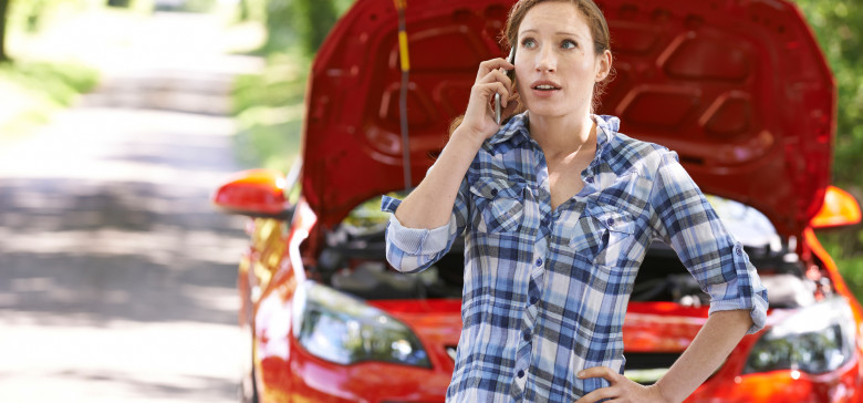 Female Motorist Phoning For Help After Breakdown