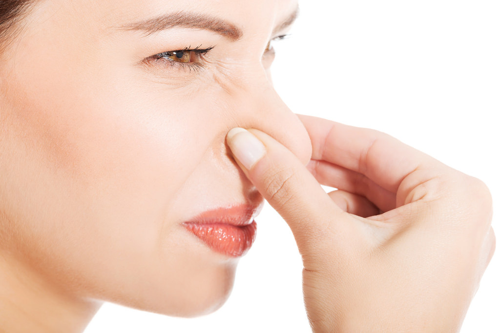 Woman holding her nose.