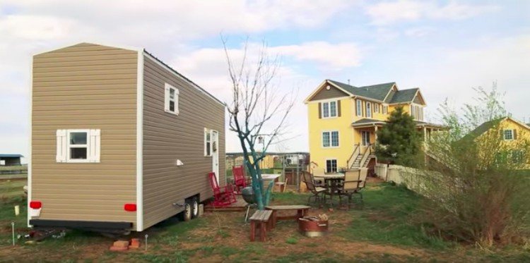 view of tiny home behind yellow house