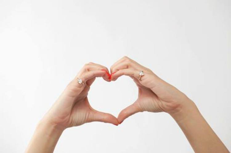 Image of heart formed by two hands wearing pinky rings.