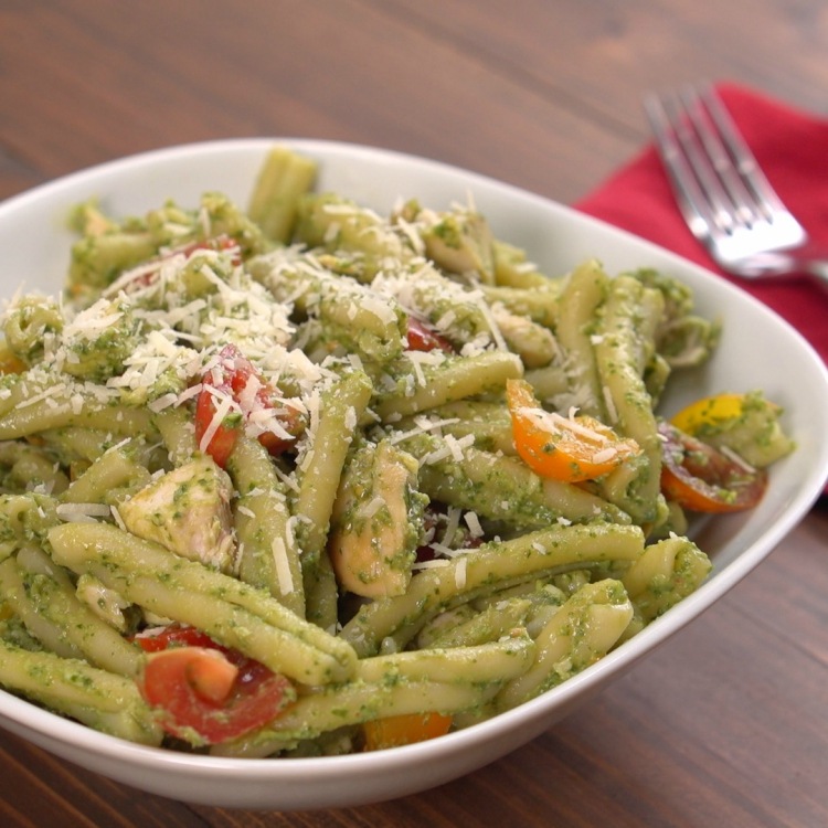 Bowl of avocado pesto chicken pasta topped with Parmesan