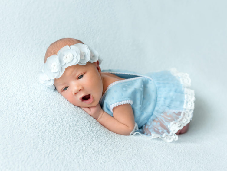 Image of Cute newborn baby girl in a blue dress