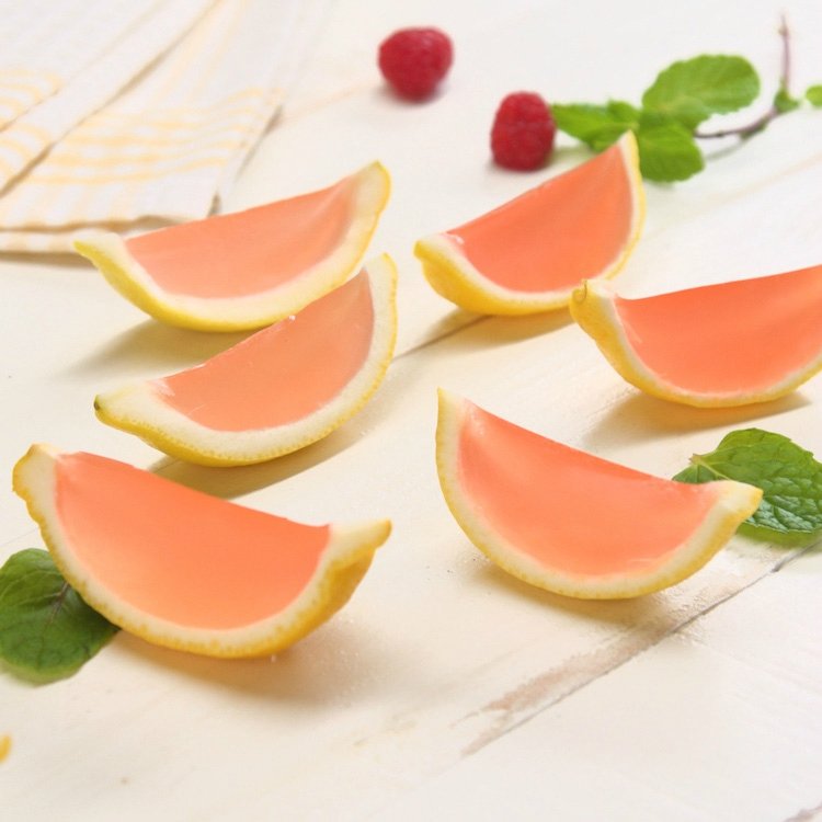 6 homemade pink lemonade Jell-O shots in lemon wedges