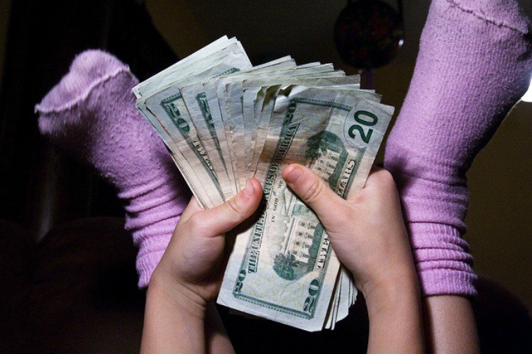 Image of child holding money.