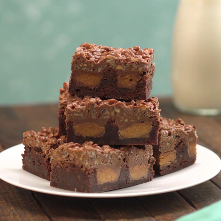 Fudgy brownies topped with a crackly layer of crispy rice cereal coated in melted chocolate and crunchy peanut butter--with a surprise peanut butter cup center.