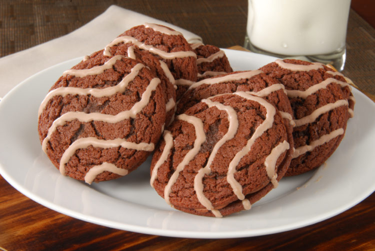 Image of a plate of molasses cookies with a glass of milk