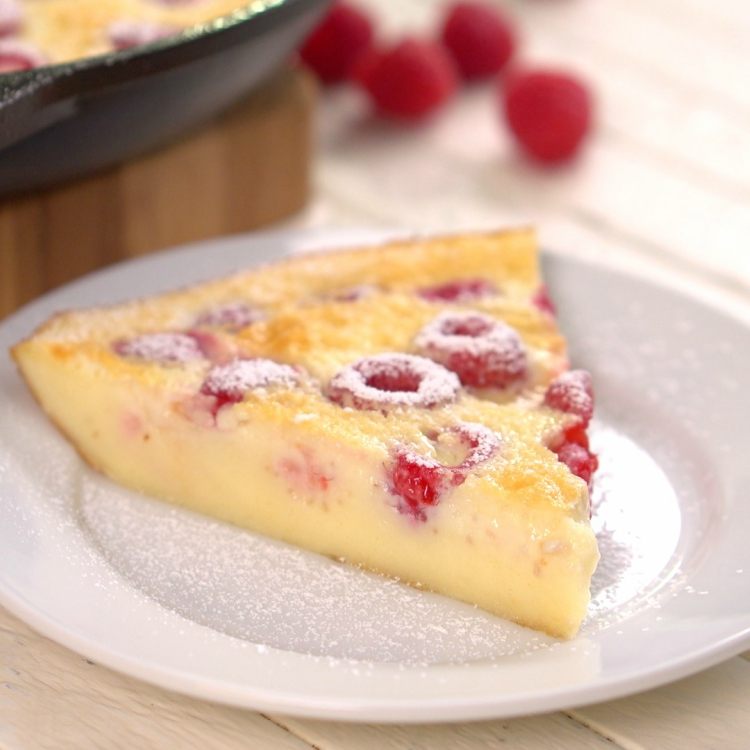 Slice of raspberries baked in custard called clafoutis