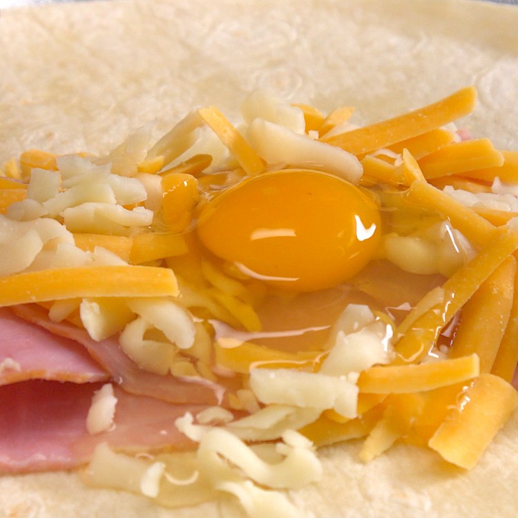 Easy, portable breakfast pockets stuffed with ham, gooey melted cheese, and a perfectly-done baked egg. The best part is, there's absolutely zero clean-up.