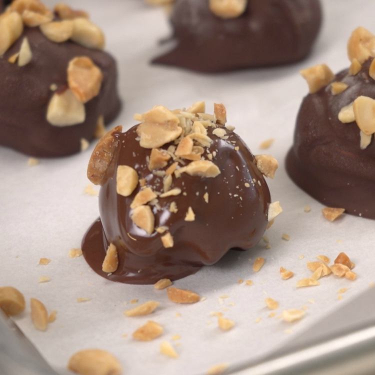 Sprinkle dipped peanut butter cheesecake balls with chopped roasted peanuts