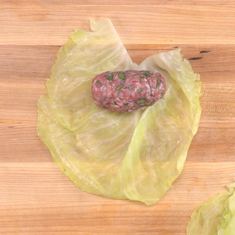Place meat horizontally on the cabbage leaf near the base