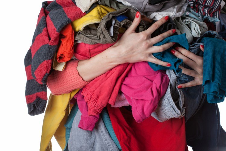 woman holding big bundle of clothing