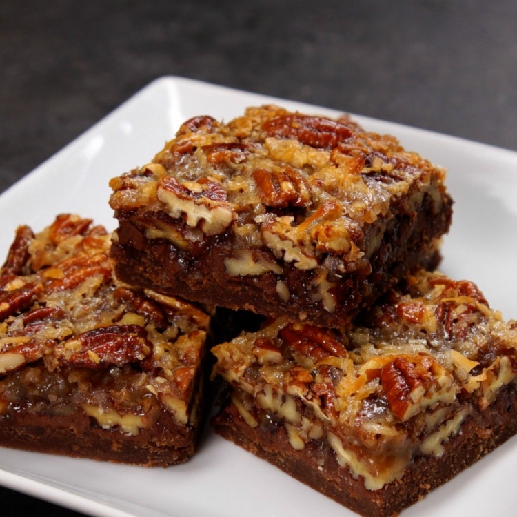4 German chocolate pecan bars on a white plate