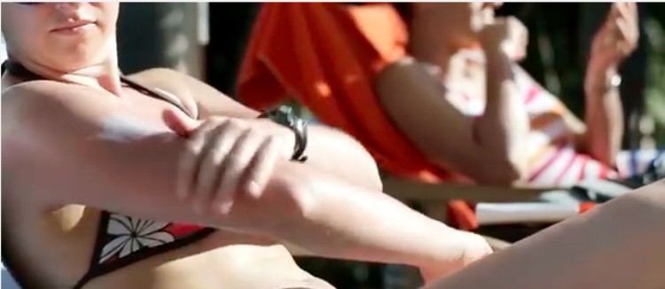 woman applies sunscreen to her arm