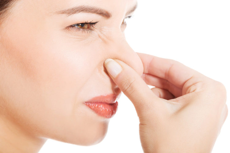 Woman holding her nose.