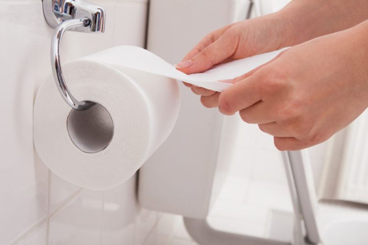 Hand pulling toilet paper.