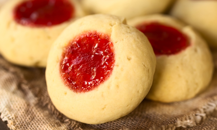 Image of Thumbprint Christmas cookies filled with strawberry jam, photographed with natural light (Selective Focus, Focus diagonally through the cookie)